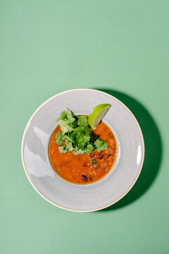 Mexican tomato soup with beans and chorizo on plate