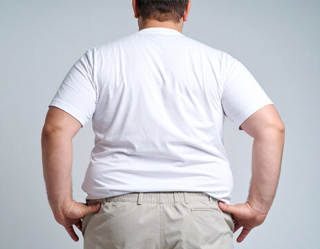 Hombre con sobrepeso de espaldas en fondo neutro, concepto de obesidad, salud y estilo de vida sedentario, representando riesgo conciencia sobre bienestar f&iacute;sico en el D&iacute;a Mundial contra la Obesidad