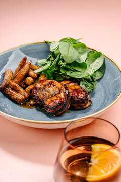 Bacon-wrapped pork medallions with baby corn and spinach