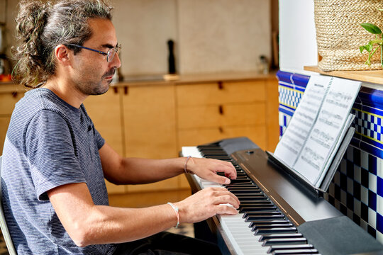 Musician works from home playing piano in a cozy kitchen