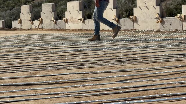 Construction worker inspecting rebar reinforcement for concrete slab