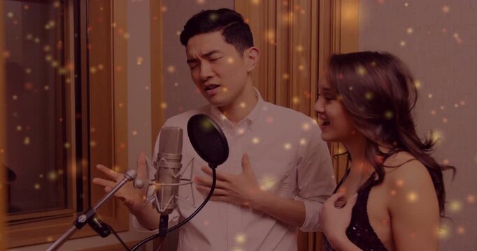 Male lead recording emotive vocal, female harmonizing and mirroring cues, gold particles around mic