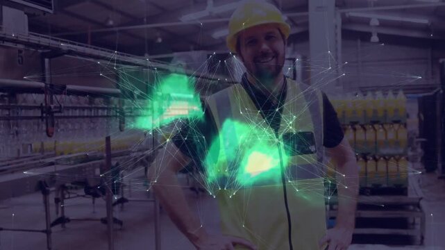 Factory worker posing as green hologram appearing, fading in plant, wearing hardhat, hi-vis vest