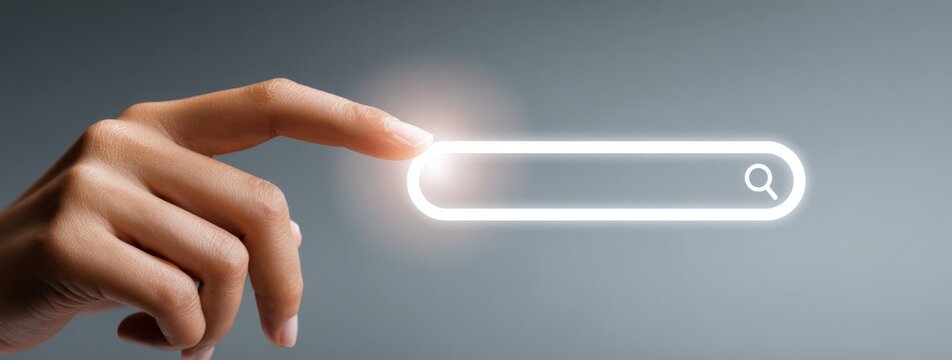 Hand touching a glowing web search bar on a gray background  