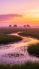 Obraz premium Serene River Bend at Dawn: A tranquil river meanders through a vibrant marshland as the soft hues of dawn paint the sky, creating a breathtaking panorama of peace and natural beauty.