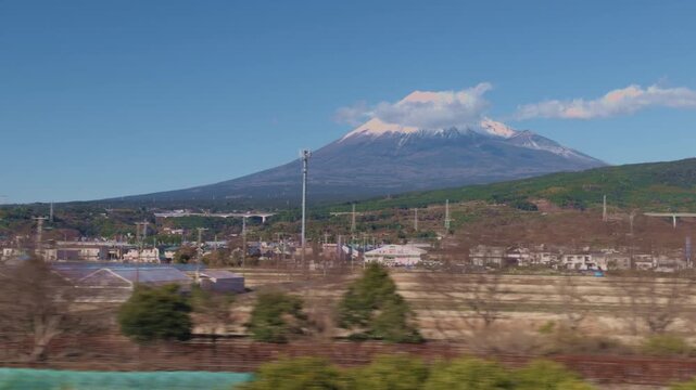 Mt Fuji Japan viewed from a moving train on a clear blue sky day