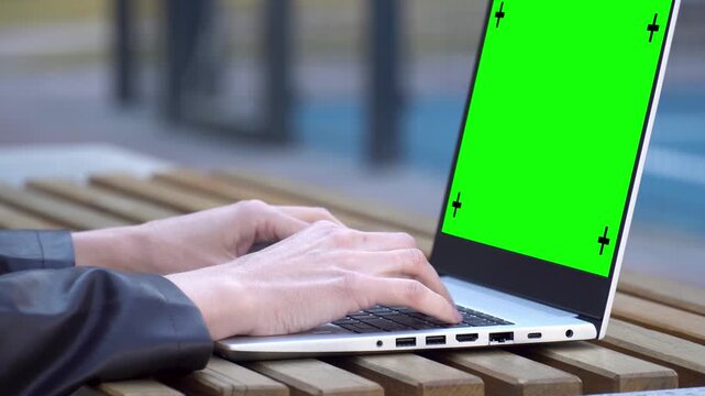 Woman Hands Typing On Laptop Green Screen With Tracking Markers Outdoors On Wooden Table