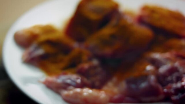 Close up of hand seasoning lamb with mixed spices