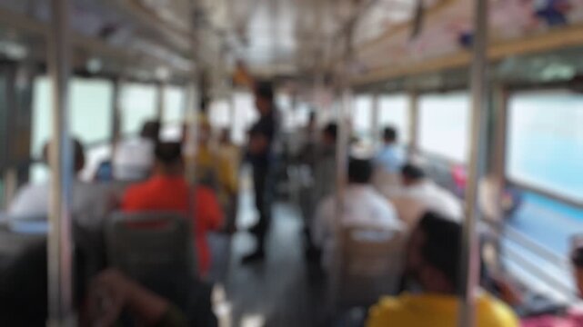 Bokeh view of passengers sitting in a city public bus, Mumbai, India. Blurred background footage.
