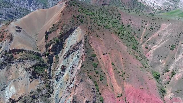 Aerial scene shows mineral outcrop plus ore deposit across red hillside, mining geology terrain. Overhead panorama reveals exposed strata with surface lode along crimson slopes, resource prospecting.