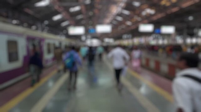 Bokeh view of passengers at the CSMT (Chhatrapati Shivaji Maharaj Terminus) railway station, Mumbai, India. Blurred background footage.