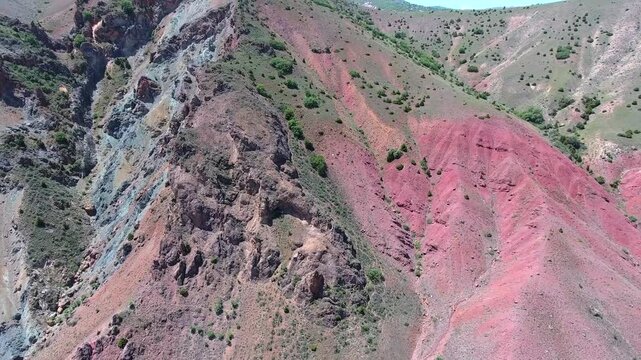 Aerial scene shows mineral outcrop plus ore deposit across red hillside, mining geology terrain. Overhead panorama reveals exposed strata with surface lode along crimson slopes, resource prospecting.