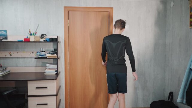 Caucasian grandson opening wooden bedroom door and pausing, steps into study area, glances at desk and shelves, backpack on floor, soft window light, teenage hesitation, domestic interior vibe