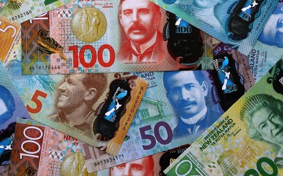 New Zealand dollar money bills pile on table. New Zealand banknotes of NZD currency close up.