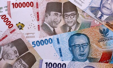 Indonesian rupiah money bills pile on table. Indonesia banknotes of IDR currency close up. © Larysa