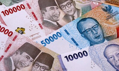 Indonesian rupiah money bills pile on table. Indonesia banknotes of IDR currency close up. © Larysa