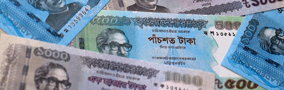 Bangladeshi taka money bills pile on table. Bangladesh banknotes of BDT currency close up.