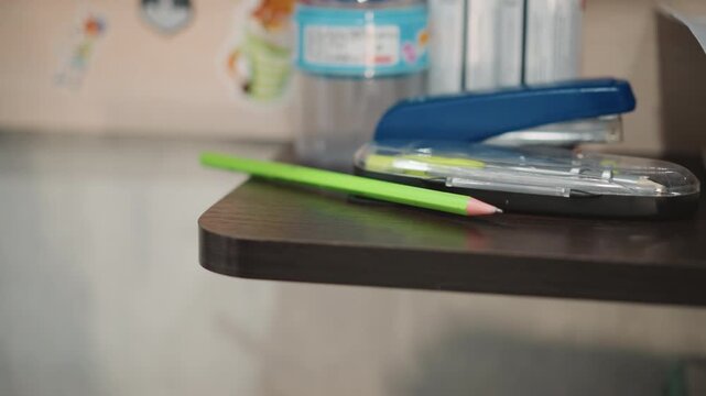 Young boy selects vibrant pencils from shelf. Young grandson chooses bright colored pencils from art case. Child reaches for vivid green and blue pencils on shelf in cozy corner for drawing