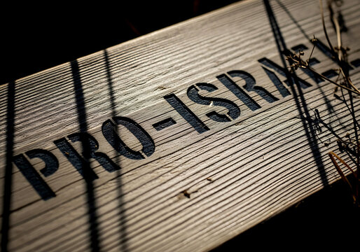 A wooden sign with pro-israel text under harsh sunlight, symbolizing support for the idf in the middle east conflict