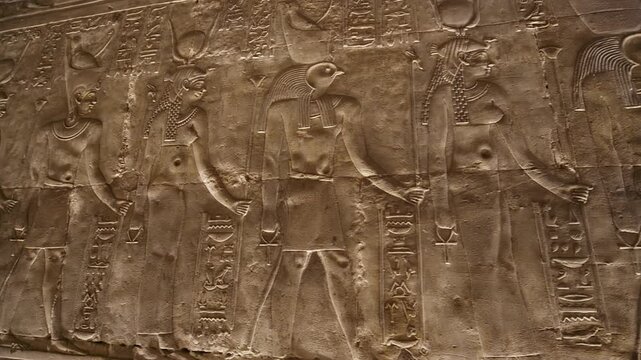 Hieroglyphs and images of Egyptian gods at the Ancient Egyptian Temple of Edfu. Edfu is the site of a Ptolemaic-era Temple of Horus and an ancient settlement in Egypt.