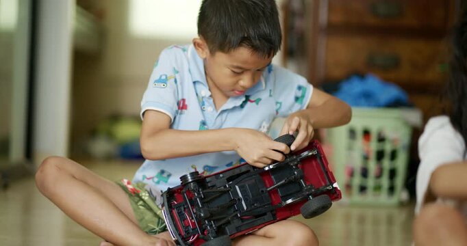 Little asian kids boy and girl enjoy play toy car fix repair in cozy room kids education