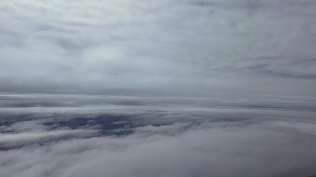 Aerial cloudscape taken from a jet airplane cockpit while flying between layers of ethereal stratus clouds. Hyperlapse accelerated x5.
