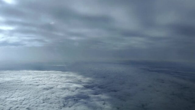 Immersive hyperlase accelerated x5 taken from a jet airplane cockpit while flying between layers of fluffy stratus clouds in a blue sky.