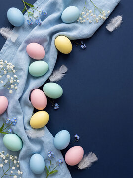 Easter banner with painted eggs and napkin on dark blue backround. Top view, flat lay with copy space.