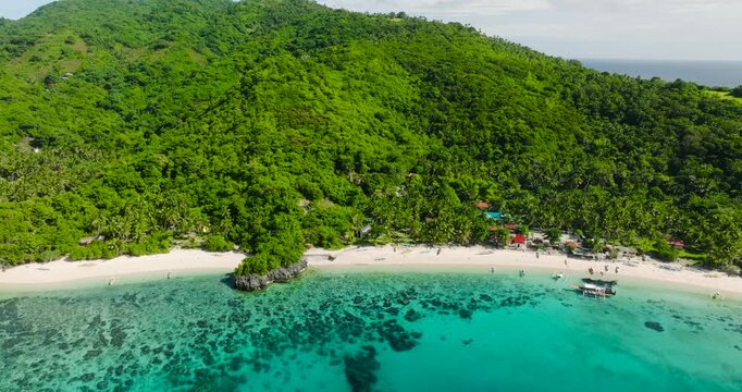 Cobrador Island with boats on white beach and turquoise water. Romblon, Philippines.