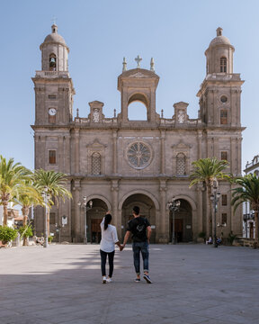Couple strolling hand in hand in front of the beautiful Cathedral of Santa Ana in Gran Canaria