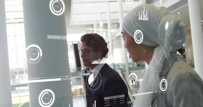 Business associates walking past railing near escalator initiating data charts and sharing insights