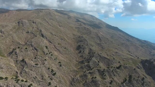 Aerial drone flight over rocky slopes of the Ethiopian Highlands near Simien Mountains peaks. Skyborne ascent above stony Abyssinian uplands around Ras Dashen summits and sparse trees.