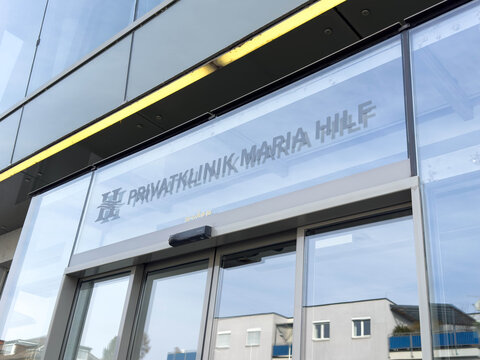 Klagenfurt, Austria - March 25, 2026: Rehabilitation center entrance with glass doors and sign reading Privatklinik Maria Hilf, modern architecture and urban setting visible