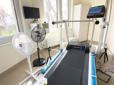 Klagenfurt, Austria - March 25, 2026: Treadmill in a rehabilitation center room with fans, monitor, and medical equipment visible in a bright, well-lit environment