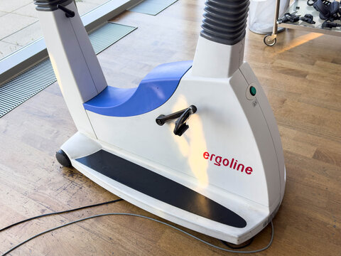Klagenfurt, Austria - March 25, 2026: Ergoline rehabilitation exercise machine with ergonomic design positioned on wooden floor in a bright rehabilitation center