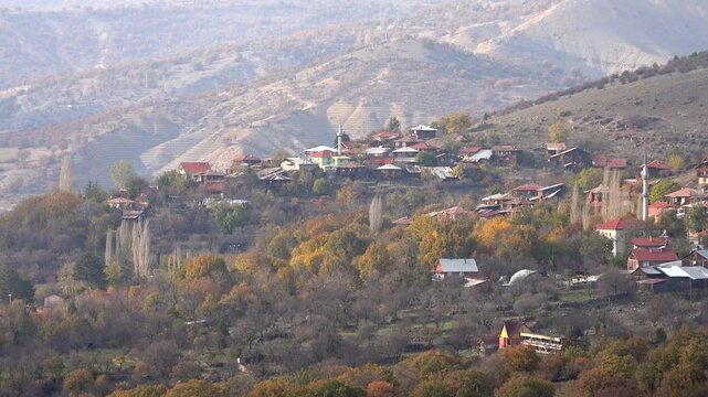 Turkish Anatolian village houses on hillside zoomed-in in autumn. Distant view capturing the traditional hamlet architecture, culture, and serene Mountain environment.