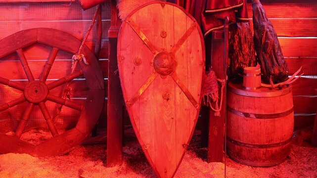 A wooden shield and a wooden wheel on a rustic background, suitable for historical or fantasy scenes
