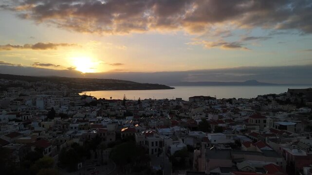 Breathtaking aerial footage of the coastal city of rethymno in crete during a golden sunset