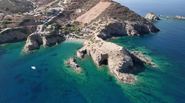 Scenic aerial shot flying over karavostasi beach and its unique cliff formations in crete, greece