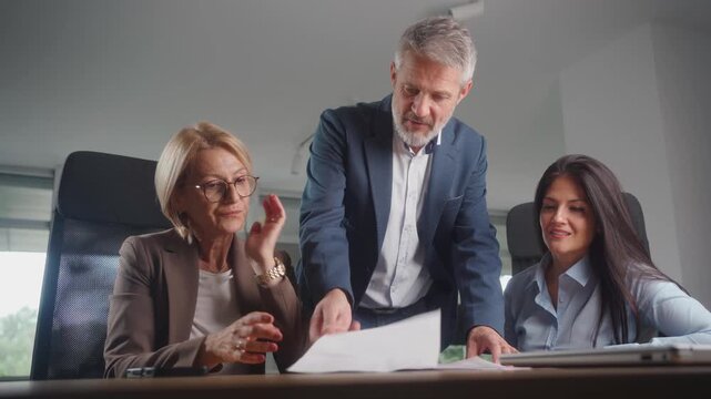 Stressed supervisor discussing poor business results with team during tense office meeting