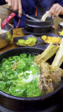 Galbitang or Korean Beef Short Rib Soup bubbling and served on a table