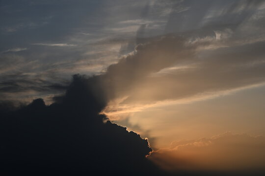 Sunbeams dramatically pierce through the clouds during sunset, creating a breathtaking Tyndall effect. This divine spectacle of light and shadow evokes awe and wonder.
