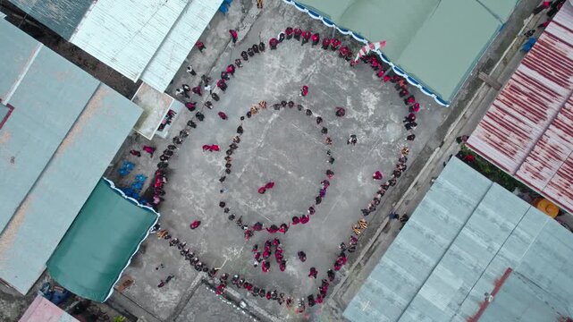 High angle drone footage of local people performing the traditional Reba dance in a circle within a tribal village in Bajawa, East Nusa Tenggara.
