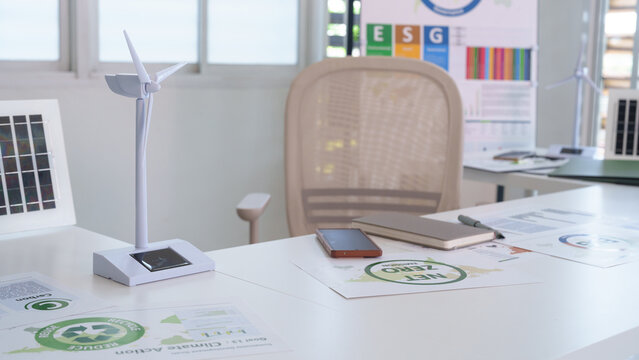 Office desk with renewable energy models sustainable reports ESG climate action and net zero emission documents for eco friendly business strategies