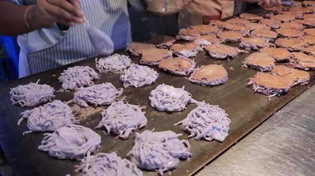Coconut flesh meets sizzling pan, footage of Kanom Babin glows with street delight