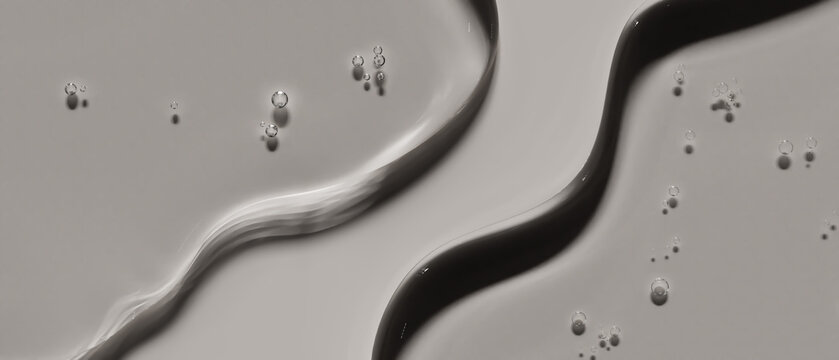 Double overlapping dark grey transparent liquid strokes flat lay on neutral surface. Conveys deep purifying charcoal cleansing concept excellent for men skincare advertising or detox face mask.