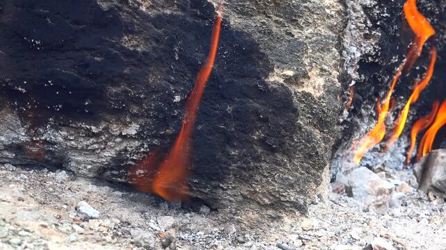 Yanartas methane flames burn through rocky vents at Cirali Antalya Turkey as eternal fire. Natural gas seepage creates a geological phenomenon with burning stone, fumarole heat, scientific interest.
