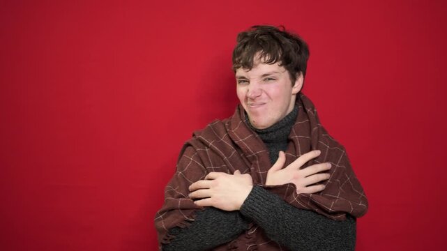 Health care concept. Stressful sick man measures temperature, eats lemon, wrapped in plaid,