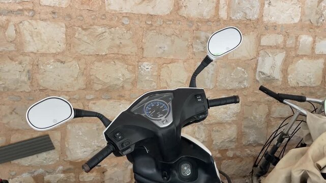 Motorcycle parked against rustic stone wall, offering unique background and textures