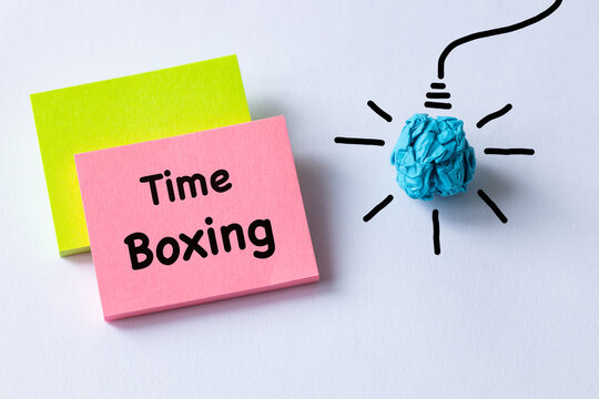 Time Boxing, written on colorful sticky notes. Business concept. The habit of setting aside time for a specific task. A light bulb made from a crumpled ball of paper. Copy space.